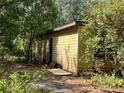 Exterior of home featuring a side entrance and overgrown landscaping at 288 Mcmillon Dr, Orange City, FL 32763