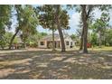 Cozy home nestled among mature trees, featuring a screened porch and spacious yard at 31544 Wekiva River Trl, Sorrento, FL 32776
