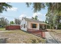 Side view of the cozy home featuring a charming screened-in porch and fenced yard at 31544 Wekiva River Trl, Sorrento, FL 32776