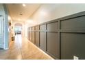 Stylish hallway with decorative gray accent wall paneling and neutral tile flooring at 343 Lazio Cir, Debary, FL 32713