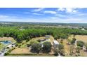 Expansive aerial view showcasing property with ponds, house, outbuildings, and surrounding trees at 4145 Rambler Ave, St Cloud, FL 34772