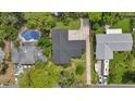A bird's eye view of the property, showcasing the pool and surrounding trees at 44 Fairway Cir, New Smyrna Beach, FL 32168