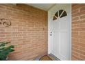 Close-up of the front door set in a brick surround, inviting and well-maintained at 44 Fairway Cir, New Smyrna Beach, FL 32168
