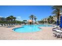 Relaxing community pool area with lounge chairs, palm trees, and a gazebo at 4670 Links Village Dr # A506, Ponce Inlet, FL 32127