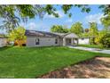 Side view of a single story home with green grass in the front yard and a long driveway at 495 6Th St, Holly Hill, FL 32117
