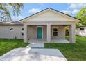 Inviting covered front porch with nice landscaping and a blue front door at 495 6Th St, Holly Hill, FL 32117