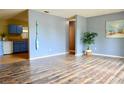 Open-concept living room featuring wood floors, a blue accent wall, and a view to the kitchen at 522 Grace Ave, Deland, FL 32724