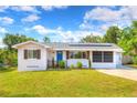 Charming single-story home with a well-manicured lawn and blue door under a bright blue sky at 738 Lindley Blvd, Deland, FL 32724