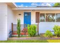Inviting front porch with a bright blue door, stylish light fixture, and well-kept landscaping at 738 Lindley Blvd, Deland, FL 32724