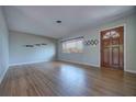 Bright living room with hardwood floors, a large window, and a classic wooden door at 738 Lindley Blvd, Deland, FL 32724