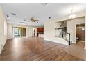 Bright, open-concept living room with hardwood floors, adjacent to kitchen, staircase, and full bathroom at 8832 Ribault Ave, Orlando, FL 32832