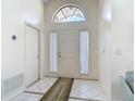 Bright foyer featuring tile flooring, arched window and a classic white front door at 907 Silver Leaf Pl, Port Orange, FL 32127