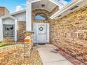 Inviting front entrance with a brick facade, decorative wreath, and manicured landscaping at 907 Silver Leaf Pl, Port Orange, FL 32127