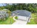 An aerial perspective of a well-maintained house featuring a lush lawn, and a driveway leading to a garage at 941 Pizarro Dr, Daytona Beach, FL 32119