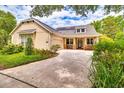 Beautifully designed home with solar panels, a manicured lawn, and a spacious driveway leading to the garage at 1018 Heron Point Cir, Deland, FL 32724
