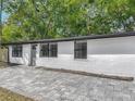 Charming single-story home featuring a fresh white exterior, gray door, and brick walkway at 102 Judges Ln, Port Orange, FL 32129