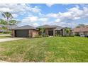 Beautifully landscaped brick home featuring a spacious front lawn and an attached two-car garage at 104 Balmoral Ct, Debary, FL 32713