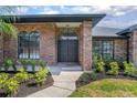 Inviting home entrance featuring a double door, brick accents, and manicured landscaping at 104 Balmoral Ct, Debary, FL 32713