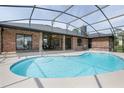 Inviting screened-in pool area with a sparkling blue pool, surrounded by a spacious deck and lush landscaping at 104 Balmoral Ct, Debary, FL 32713