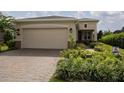 Charming single-story home with a brick driveway, well manicured lawn and colorful landscaping at 1118 Avery Meadows Way, Deland, FL 32724