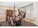 Dining room featuring hardwood floors, a classic chandelier, and seamless transition to the staircase at 123 Ivydale Manor Dr, Deland, FL 32724