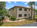 Exterior corner view of a multi-story home with neutral tones, landscaping, and manicured shrubs at 1601 Big Tree Rd # 1301, South Daytona, FL 32119