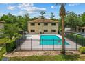 View of the community pool with an adjacent two-story condo building and neat landscaping at 1601 Big Tree Rd # 1302, South Daytona, FL 32119