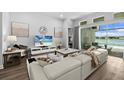 Comfortable living room with modern decor, a large TV, and sliding glass doors to the patio and lake at 165 Azure Mist Way, Daytona Beach, FL 32124