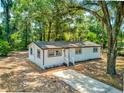 Charming single-story home featuring white siding, modern windows, and a well-maintained yard, all enhanced by mature trees at 165 S Massachusetts Ave, Deland, FL 32724