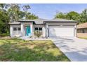 Inviting home exterior with a bright turquoise front door and attached two-car garage at 1738 Palm Rd, Ormond Beach, FL 32174