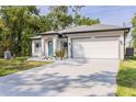 Well-lit exterior of a single-Gathering home featuring a spacious driveway leading to a two-car garage at 1738 Palm Rd, Ormond Beach, FL 32174
