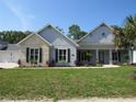 Well-maintained home showcasing a lush lawn, stone accents, and a charming covered entryway at 1870 Pepper Tree Ln, Deland, FL 32720