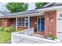 Inviting brick home with a charming blue front door, white picket fence, and well-maintained landscaping at 20 Monroe Ave, Debary, FL 32713