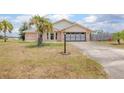 Charming brick home with a well-manicured lawn and a palm tree, featuring a spacious driveway at 2055 Little Farms Ct, Deltona, FL 32738