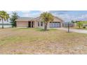 Charming brick home with a well-manicured lawn and a palm tree, located near a lake at 2055 Little Farms Ct, Deltona, FL 32738
