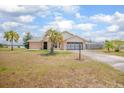 Charming brick home with a well-manicured lawn and a palm tree, located near a lake at 2055 Little Farms Ct, Deltona, FL 32738