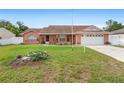 Inviting single-Gathering home with a brick facade, green lawn, and attached two-car garage at 2287 Belen Dr, Deltona, FL 32738