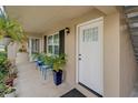 Condo entryway with bright white front door and a cozy front patio with seating and plants at 2500 Lee Rd # 134, Winter Park, FL 32789