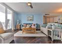 Bright living room featuring wood floors, a ceiling fan, and sliding doors to the balcony at 2800 N Atlantic Ave # 206, Daytona Beach, FL 32118