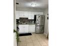 Bright kitchen featuring white cabinets, stainless steel appliances, and a stylish backsplash at 2841 Beal St, Deltona, FL 32738