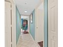 Hallway with light blue walls and white tile floors leading to bedroom at 2967 S Atlantic Ave # 202, Daytona Beach Shores, FL 32118