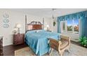 Cozy bedroom featuring dark wood floors and furniture with floral bedding and ocean view at 2967 S Atlantic Ave # 202, Daytona Beach Shores, FL 32118