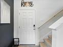 Interior entry showcasing neutral decor, staircase, 'Home Sweet Home' decor, and a modern black and white painting at 3049 Meleto Blvd, New Smyrna Beach, FL 32168