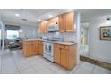 Bright kitchen featuring tile floors, wood cabinets, and a full appliance package at 3145 S Atlantic Ave # 503, Daytona Beach Shores, FL 32118