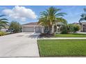 Well-maintained home featuring a three-car garage, manicured lawn, and tropical landscaping at 3229 Medici Blvd, New Smyrna Beach, FL 32168