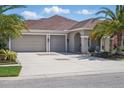 Inviting home featuring a three-car garage, covered porch, and well-manicured lawn at 3229 Medici Blvd, New Smyrna Beach, FL 32168