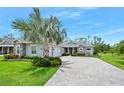 Charming home featuring a beautiful palm tree and a paved driveway leading to a two-car garage at 3322 Modena Way, New Smyrna Beach, FL 32168
