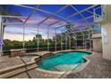 Sparkling pool with jacuzzi and waterfall feature surrounded by a screened enclosure at 340 Hampton Hills Ct, Debary, FL 32713