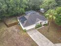 Aerial view of a home with a screened-in pool, fenced yard, solar panels, and a long driveway at 400 Landress Ln, Deland, FL 32724