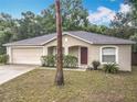 Inviting one-story home featuring a two-car garage, mature landscaping, and a covered entryway at 400 Landress Ln, Deland, FL 32724